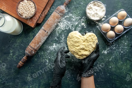 Preview: top view female cook holding heart shaped dough on dark background cake job oven hotcake bake worker