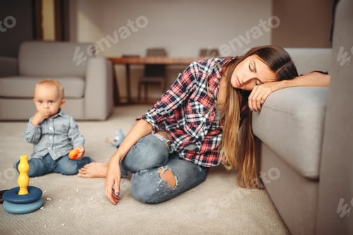Preview: Little kid playing on the floor, mother sleeps