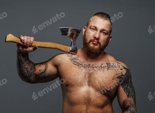 Preview: Brutal big man with tattooes and beard holding axe