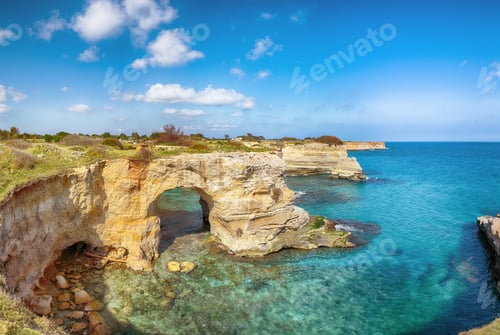 Preview: Stunning seascape with cliffs rocky arch and stacks (faraglioni) at Torre Sant Andrea
