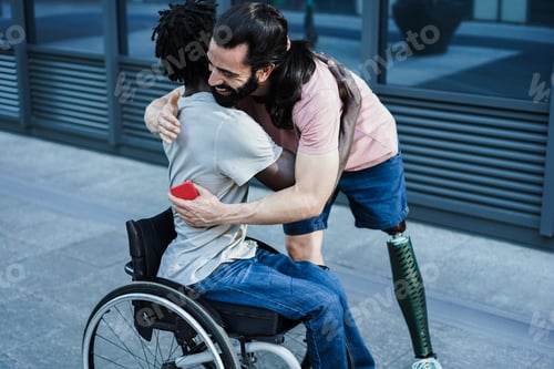 Preview: Multiracial friends with disability hugging each other outdoor - Focus on right man arm