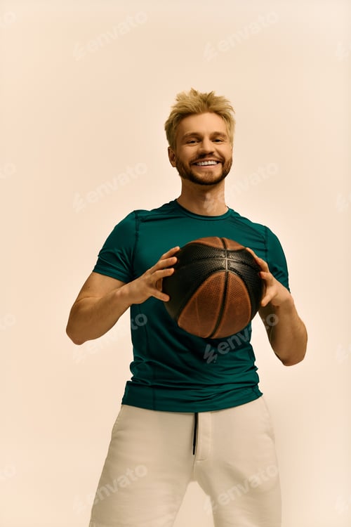 Preview: Young man with a basketball showcasing his charm and energy in a studio setting