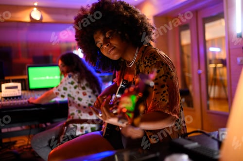 Preview: A multicultural bass player recording a part of her song in a music studio.