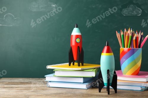 Preview: Bright toy rockets and school supplies on wooden table