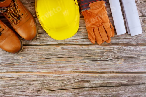 Preview: Industry worker protective workwear safety boots leather gloves yellow hard hat on architects