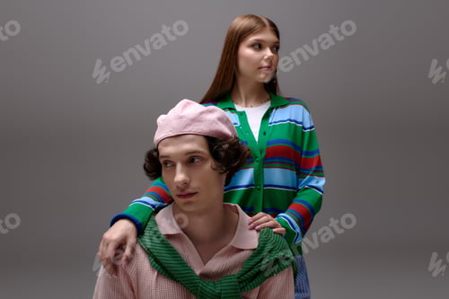 Preview: Stylish young couple shines in fashionable outfits against a sleek grey backdrop