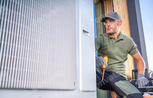 Preview: Air Conditioning Technician Servicing Unit Outdoors in Bright Daylight