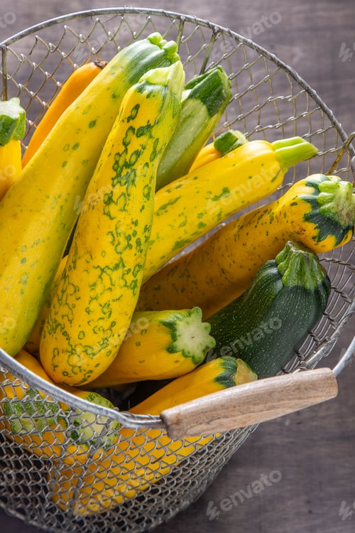 Preview: Yellow-green leopard-spotted zucchini. Vegetables on the table. Zucchini harvest.