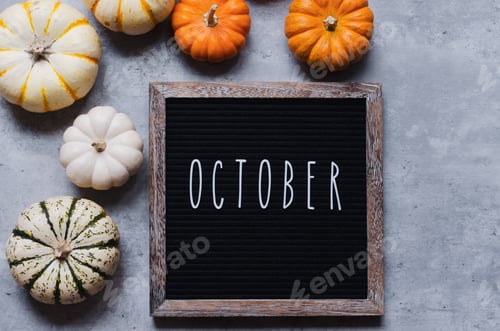 Preview: The word October spelled out on a black felt letter board with orange pumpkins gourds