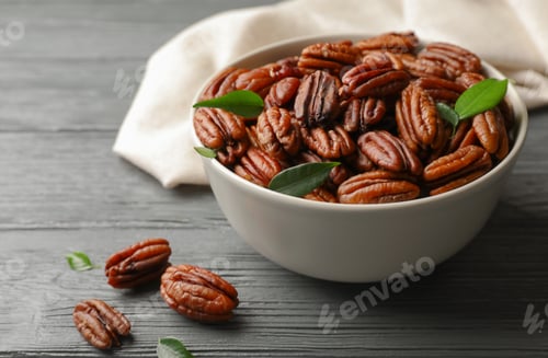Preview: Dish with tasty pecan nuts on wooden table