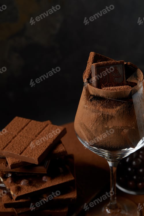 Preview: close-up view of glass and delicious assorted chocolate pieces on black
