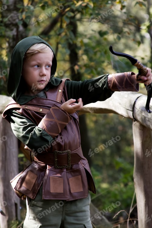 Preview: Portrait of a boy in a medieval costume holding a bowstring against a forest background
