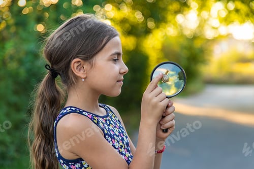 Preview: A child is studying a snail in the park. Selective focus.