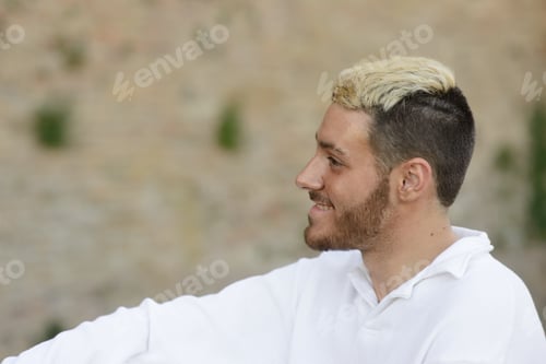 Preview: Smiling young man with trendy hairstyle outdoors