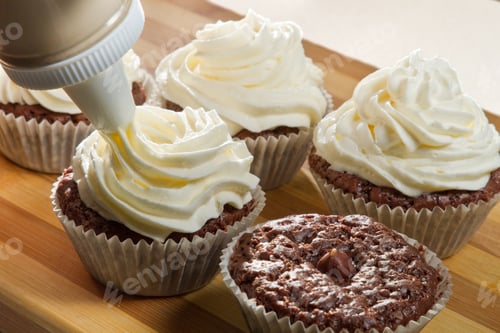 Preview: Decorating chocolate muffin with vanilla cream