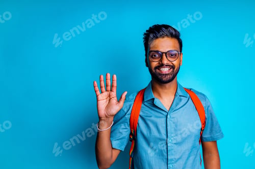 Preview: indian student man feeling happy looking at camera wear eye glasses and orange backpack and saying