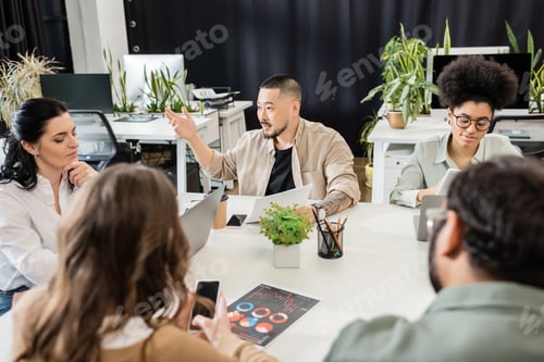 Preview: asian man sharing ideas with team lead and colleagues while working together on startup project