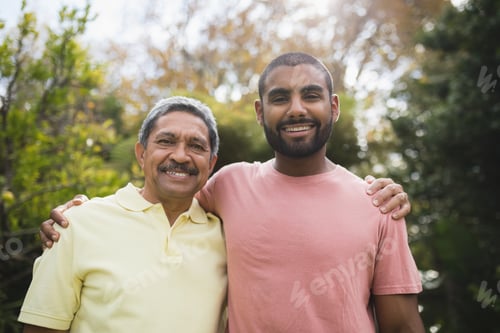 Preview: Portrait of smiling man with his father standing at park