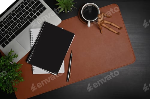Preview: Stylish workplace with laptop computer, notebook and coffee cup on black table.