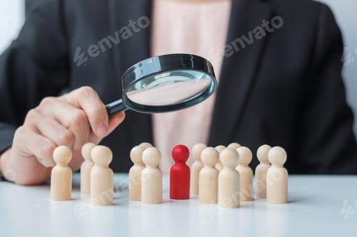 Preview: Businesswoman hand holding magnifying glass for recruiting leader man wooden from crowd of employees