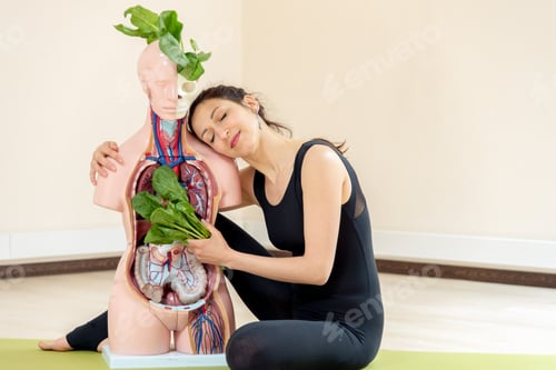 Preview: A Yoga Coach Sits Next To A Medical Dummy