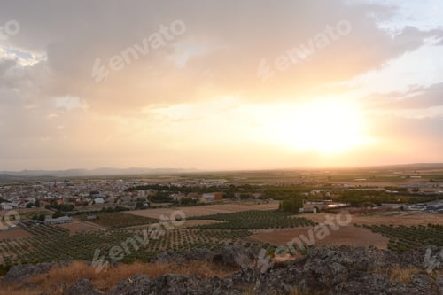 Preview: Beautiful scenery of a plain landscape with a big town on a sunset background