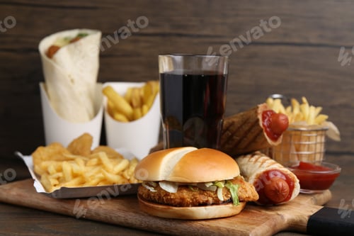Preview: Different delicious fast food and cola on wooden table, closeup