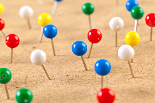 Preview: Group of thumbtacks pinned on corkboard