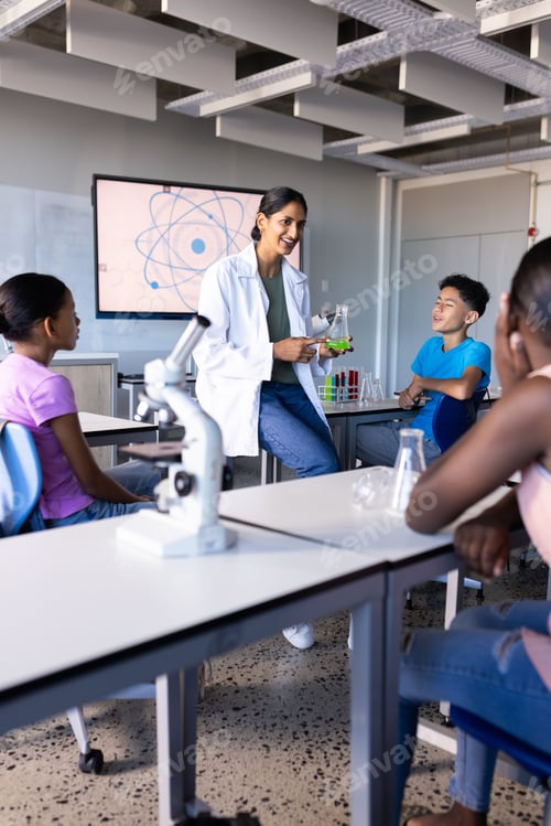 Preview: In school, Indian female teacher demonstrating science experiment to students in classroom