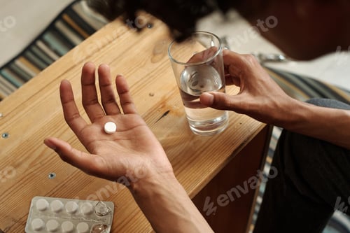 Preview: Male hands with pill and glass of water