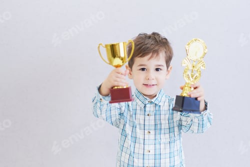 Preview: funny boy age three years old, holding in holding a trophy