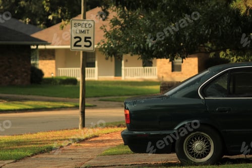 Preview: Car standing outdoors along with a road sign stating the speed limit
