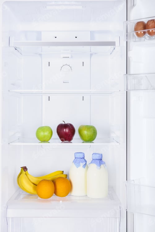 Preview: ripe tasty fruits and bottles of milk in fridge