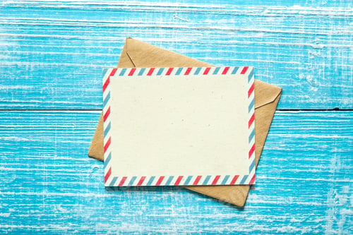 Preview: Envelope and postcard for text on a blue wooden background, top view.
