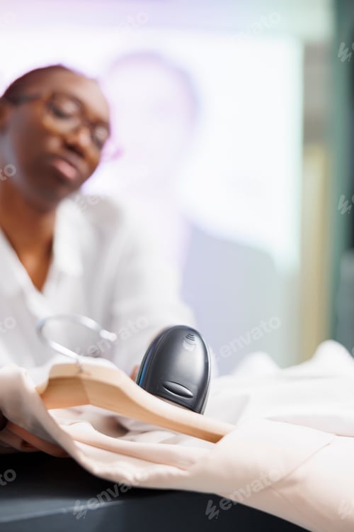 Preview: Clothing store cashier scanning items at checkout counter
