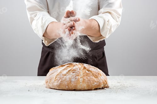 Preview: The male hands in flour and rustic organic loaf of bread