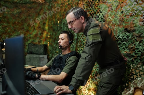 Preview: Young serious officer of command and control center looking at computer screen