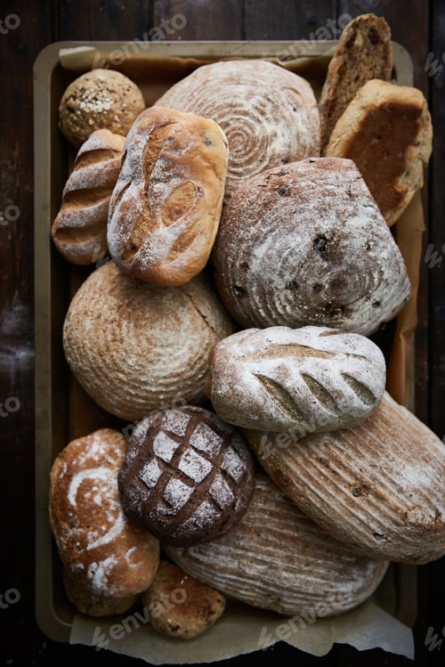 Preview: some breads and rolls are piled on a plate in a wooden crate