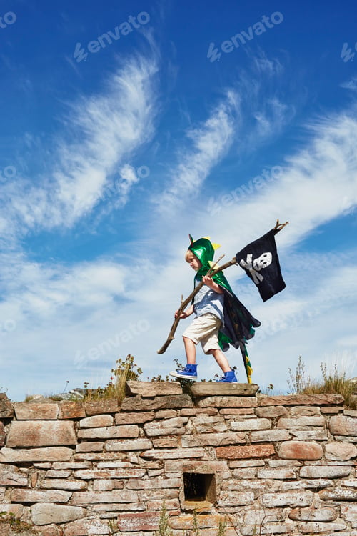 Preview: Adventurous child marching atop a stone wall, flying a pirate flag high into the blue sky.