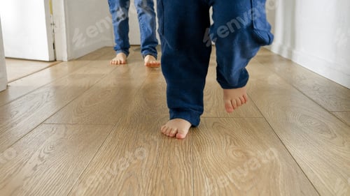 Preview: Happy children's feet playing football on wooden floor at corridor in house. Children happiness, fun