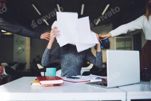 Preview: Woman covering face with papers in office