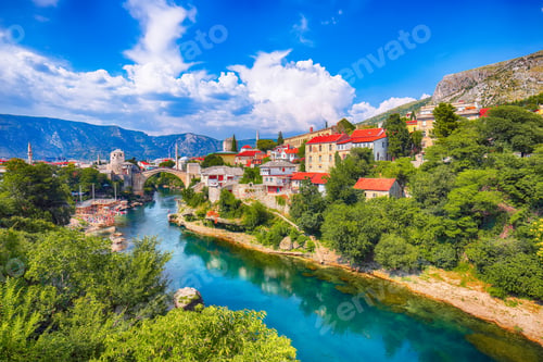 Preview: Fantastic Skyline of Mostar with the Mostar Bridge, houses and minarets, during sunny day.