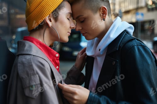 Preview: Two women in love stand near wall of large building