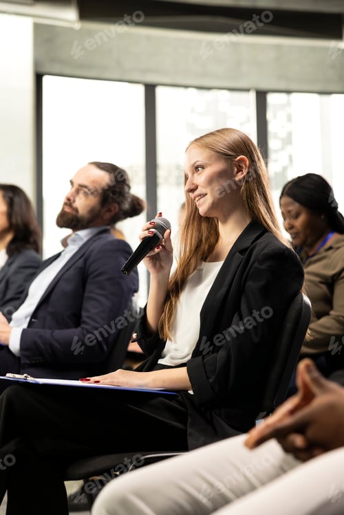 Preview: Young female journalist asking questions on microphone and taking notes
