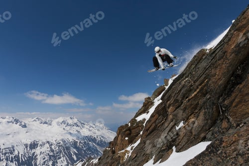 Aperçu: Snowboarder jumping on rocky slope