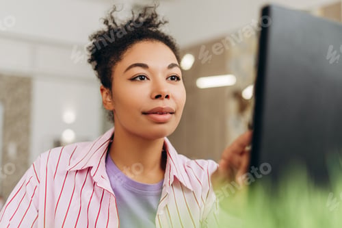 Preview: Focused female entrepreneur working on desktop computer in modern office