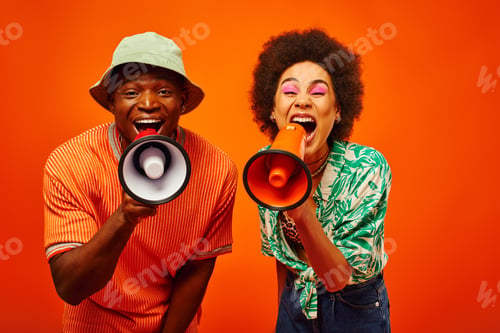 Preview: Excited young and stylish african american best friends in summer outfits screaming at loudspeakers