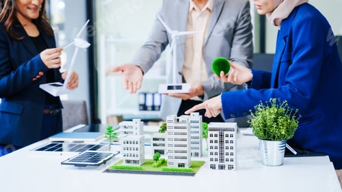 Preview: Trio of businesspeople, including a middle-aged Asian man and woman, strategize at their desk