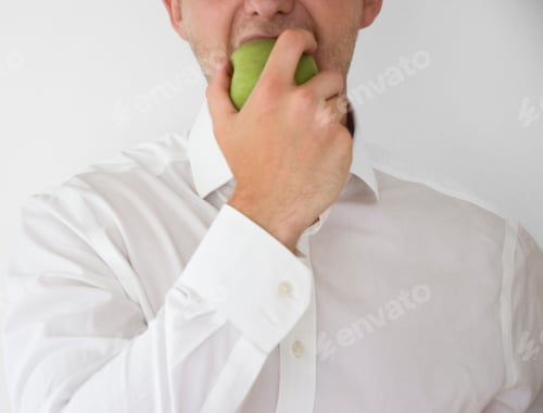 Preview: Businessman eating a green apple