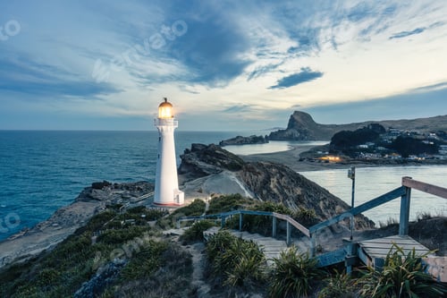 Preview: View of Castlepoint Lighthouse with beam on Wairarapa coast in the evening at New Zealand